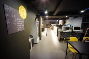 a restaurant with yellow chairs and a chalkboard on the wall at BRB Hostel Bangkok Silom in Bangkok