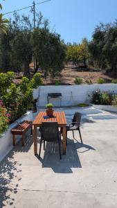 a wooden table and chairs with a potted plant on it at Villa Elia Acharavi in Acharavi