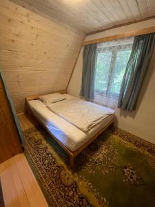 a bed in a small room with a window at Chata Buková in Brezina