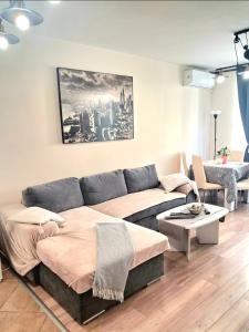 a living room with a couch and a table at Juls 2 bed flat- Bulgaria mall FREE parking in Sofia +17 photos