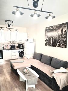 a living room with a couch and a kitchen at Juls 2 bed flat- Bulgaria mall FREE parking in Sofia