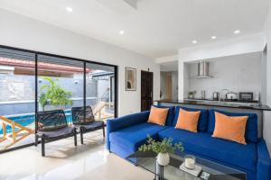 a living room with a blue couch and a kitchen at Luxury Pool Villa Pattaya Center C8 - 4 Bedroom in Pattaya South