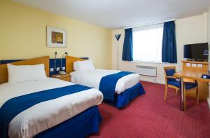 a hotel room with two beds and a desk at Holiday Inn Express Bradford City Centre by IHG in Bradford +31 photos
