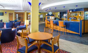 a restaurant with tables and chairs and a bar at Holiday Inn Express Bradford City Centre by IHG in Bradford