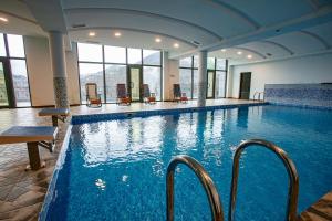 a large swimming pool with chairs in a building at Nairi Hotel in Jermuk