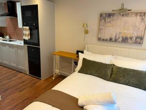 a small room with a bed and a kitchen at Cozy Studio in Eccles - Salford, Manchester in Manchester +23 photos