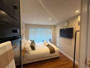 a bedroom with a large bed with a window at Cozy Studio in Eccles - Salford, Manchester in Manchester