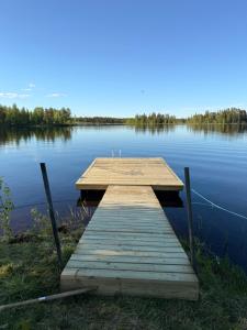 a wooden dock sitting on the side of a lake at Fishermans luck in Arvidsjaur