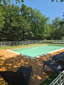 a swimming pool with two tables and two chairs at Mazet sous les chênes in Valaurie