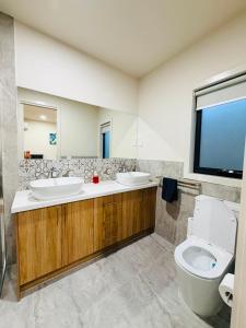 a bathroom with two sinks and a toilet at Grand Suite with Ensuite Bathroom in Wyndham Vale +11 photos