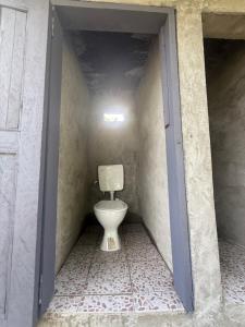 a small bathroom with a toilet in a doorway at Fireworks bungalows in White Sands