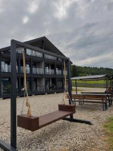 a playground with swings in front of a building at Park House in Palyanytsya