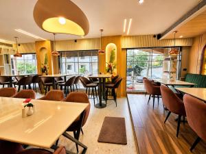 a restaurant with tables and chairs and windows at HOTEL in PURI - SWIMMING POOL RB - Near Sea Beach & Shree Jagannath Temple - wifi - Parking - Restaurant - in Puri