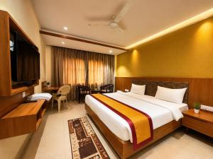 a hotel room with a large bed and a desk at HOTEL in PURI - SWIMMING POOL RB - Near Sea Beach & Shree Jagannath Temple - wifi - Parking - Restaurant - in Puri