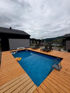 a large swimming pool on a deck with a wooden deck at Park House in Palyanytsya