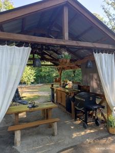 an outdoor kitchen with awning and a grill at Wood Camping in Brochów