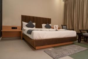a bedroom with a large bed with a wooden headboard at Sukuun Villa Airport Road #Luxury Pool Stay in Sri Guru Ram Dass Jee International Airport +37 photos