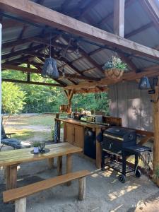 an outdoor kitchen with a picnic table and a grill at Wood Camping in Brochów