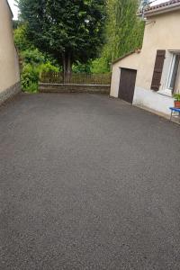 a parking lot with a tree and a house at Au bord de La Boëme in Mouthiers-sur-Boëme