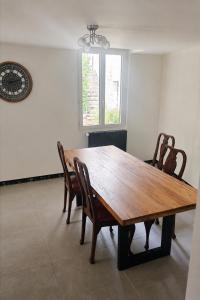 a wooden table and chairs in a room at Au bord de La Boëme in Mouthiers-sur-Boëme