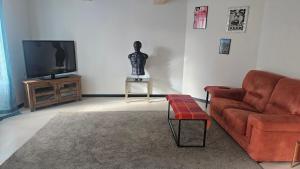 a living room with a couch and a television at Au bord de La Boëme in Mouthiers-sur-Boëme