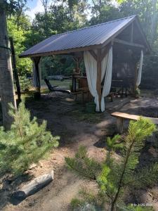 a gazebo with a table and a bench at Wood Camping in Brochów