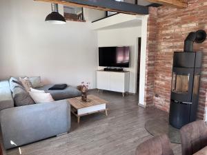 a living room with a couch and a brick wall at Ferienwohnung Sabrina in Aichen