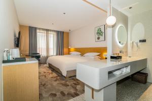 a hotel room with a bed and a bathroom at Aomori Hotel -Foshan Shunde Qinghui Garden Resort OCT Harbour PLUS Branch in Shunde