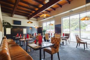 a restaurant with tables and chairs and windows at The Ashley Hotel Greymouth in Greymouth