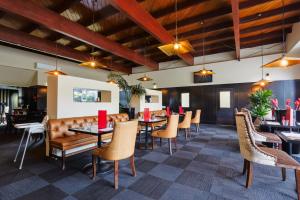 a dining room with tables and chairs and wooden ceilings at The Ashley Hotel Greymouth in Greymouth
