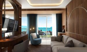 a living room with a couch and a large window at Grand Hotel Bristol in Stresa
