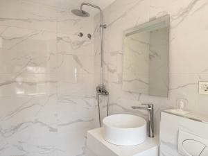 a white bathroom with a shower and a sink at Hotel Marina Benalmádena in Benalmádena +70 photos