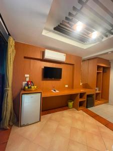 a room with a desk and a tv on a wall at PorterHouse Beach Hotel in Patong Beach