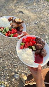 a person holding a plate of food with rice and meat at ЭКО балык Седеп юурт  +3 photos