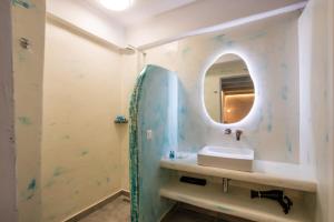 a bathroom with a sink and a mirror at Poseidon Blue Gastronomy Hotel in Afiartis +75 photos