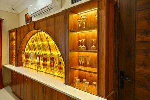 a display case in a room with glasses at Sukuun Villa Airport Road #Luxury Pool Stay in Sri Guru Ram Dass Jee International Airport