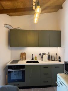 a kitchen with green cabinets and a sink at Melograno Lofou in Lofou +5 photos