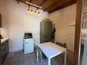 a kitchen with a white table and a white refrigerator at Melograno Lofou in Lofou