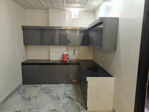 a kitchen with black cabinets and a sink at Diksha Heritage In in Prayagraj
