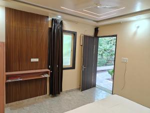 a room with a bed and a sliding glass door at Diksha Heritage In in Prayagraj