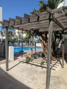a wooden pergola next to a swimming pool at Kiti 2 bedroom Penthouse in Kiti
