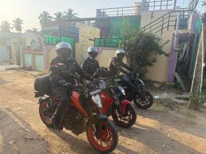 three people riding motorcycles on a dirt road at Siddhartha homevibes hampi in Hampi