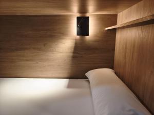 a bedroom with a bed with a light on the wall at Albergue O Centro in Portomarin