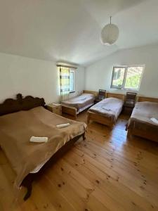 a large room with two beds and a table at Guesthouse Gama in Khevsureti in Roshka
