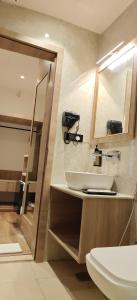 ein Badezimmer mit Waschbecken, Spiegel und Toilette in der Unterkunft Rahitya Pr,emier, Ayodhya in Faizābād