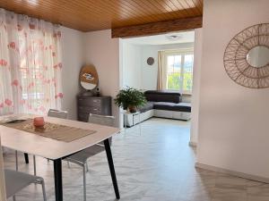 a living room with a table and a couch at Helle Wohnung nahe Bern in Worb