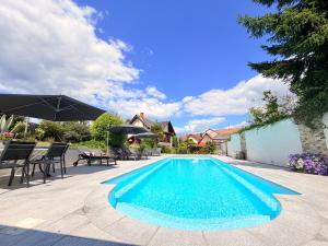 a swimming pool in a yard with chairs and umbrellas at Gîte d'exception pour 2 personnes in Mietesheim
