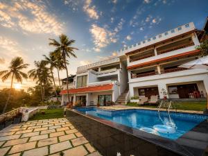 an exterior view of a house with a swimming pool at Getaway Beach Resort Kovalam in Kovalam