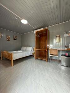 a bedroom with a bed and a table and a desk at TAGBALAYON-GARDEN Guest House in Siquijor