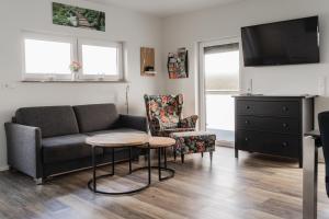 a living room with a couch and a table and a tv at Seelenruhe in Goch